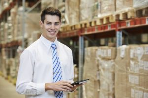 smiling manager in warehouse with tablet pc computer