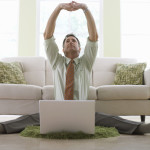 Businessman Stretching While Working on His Laptop
